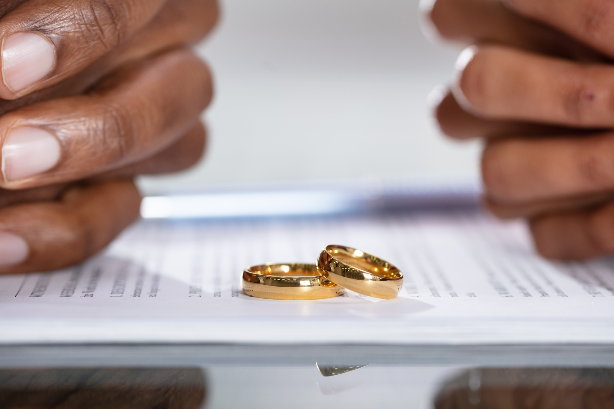 High-Asset Divorce Attorneys Washington - Couple Hands On Divorce Agreement Near Wedding Rings