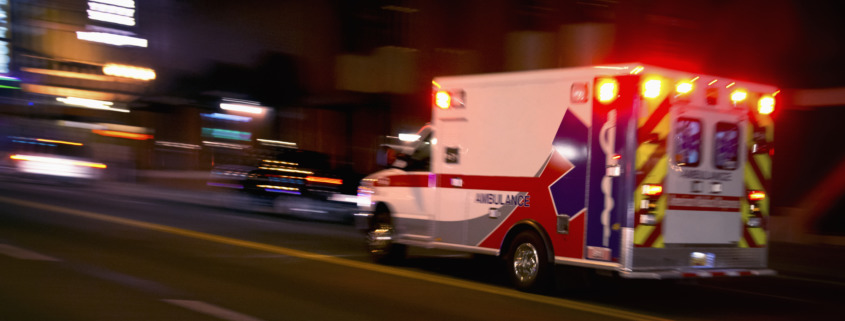 Should You Speak With An Injury Lawyer? - An ambulance speeding through traffic at nighttime